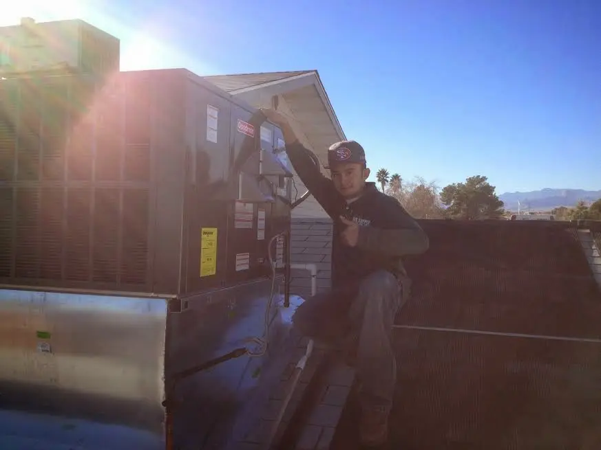 HVAC technician performing Heat Pump Repair on a rooftop unit in Douglas